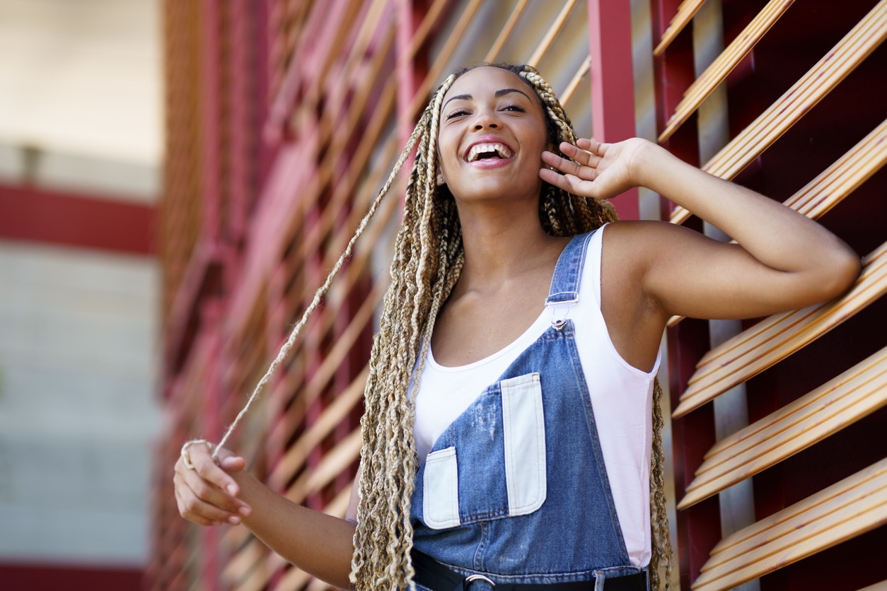 mujer feliz con trenzas rubias